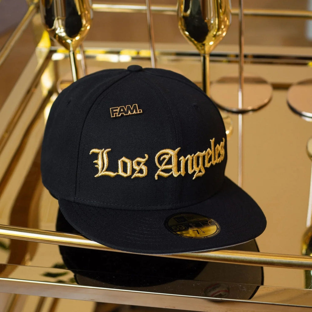 Black cap with 'Los Angeles' in gold on a reflective surface